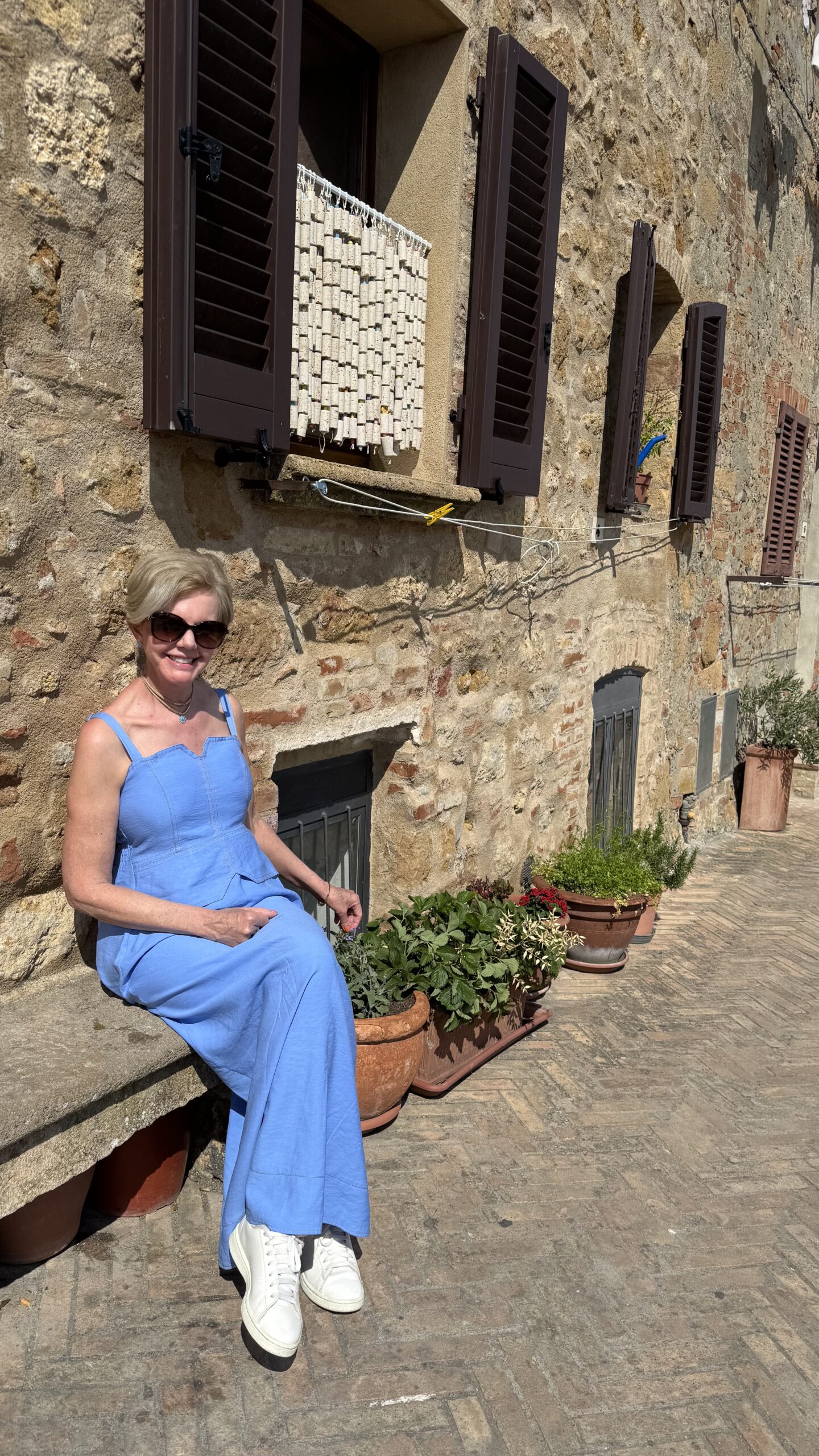 Ruela de pedra em Pienza com vasos de terracota e janelas de madeira