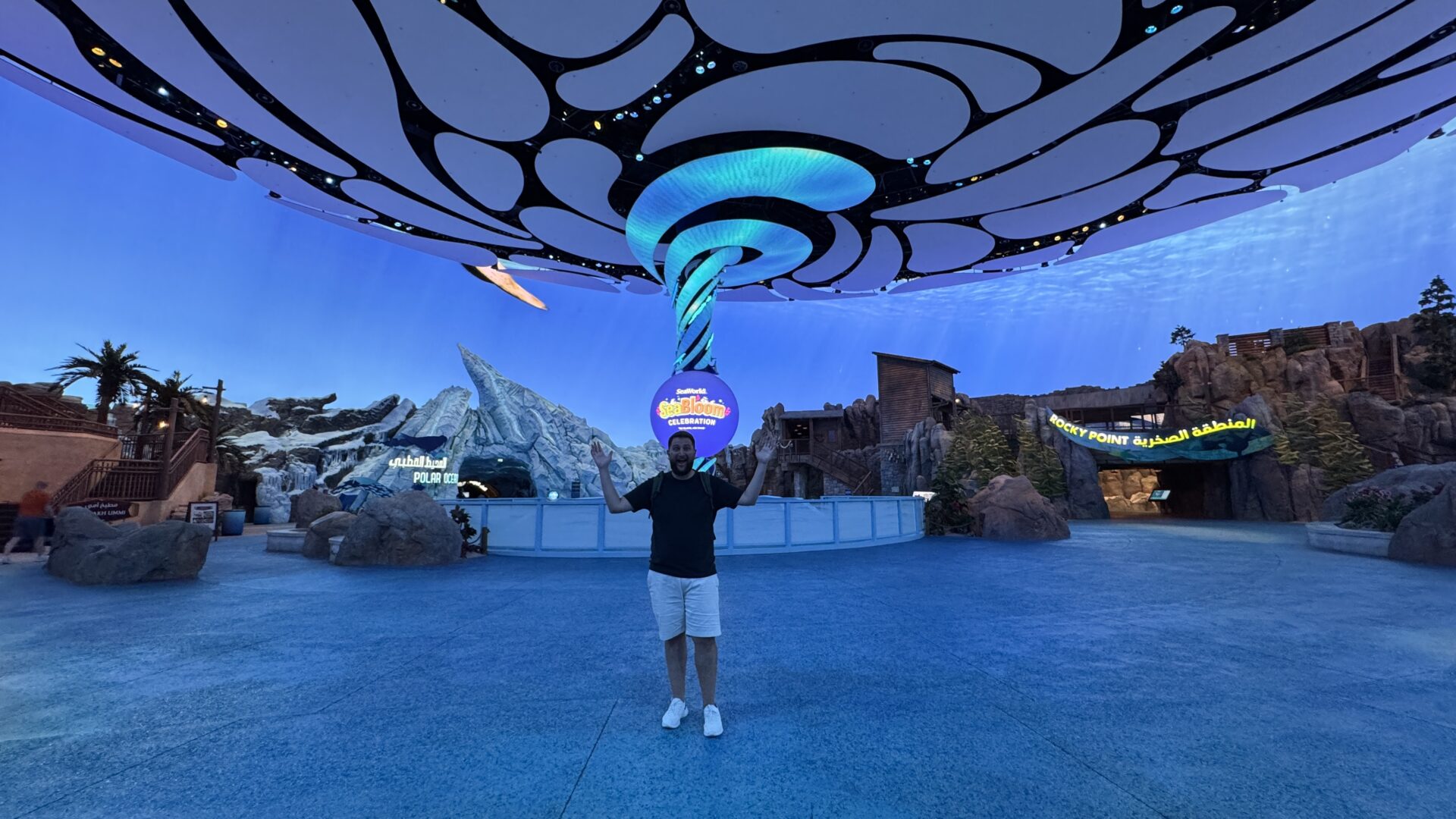 Rudi na área do SeaBloom do SeaWorld Abu Dhabi, com cenário de recife e o letreiro do Polar Ocean ao fundo