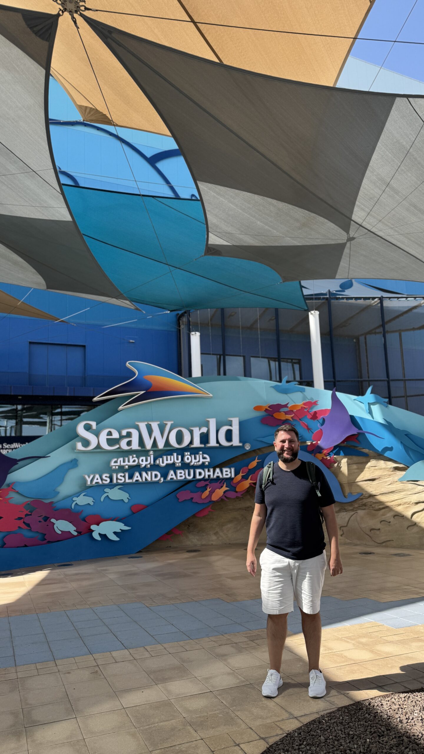 Rudi na entrada do SeaWorld Yas Island em Abu Dhabi, em frente ao letreiro do parque