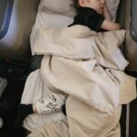 Samuel dormindo coberto na executiva da South African Airways