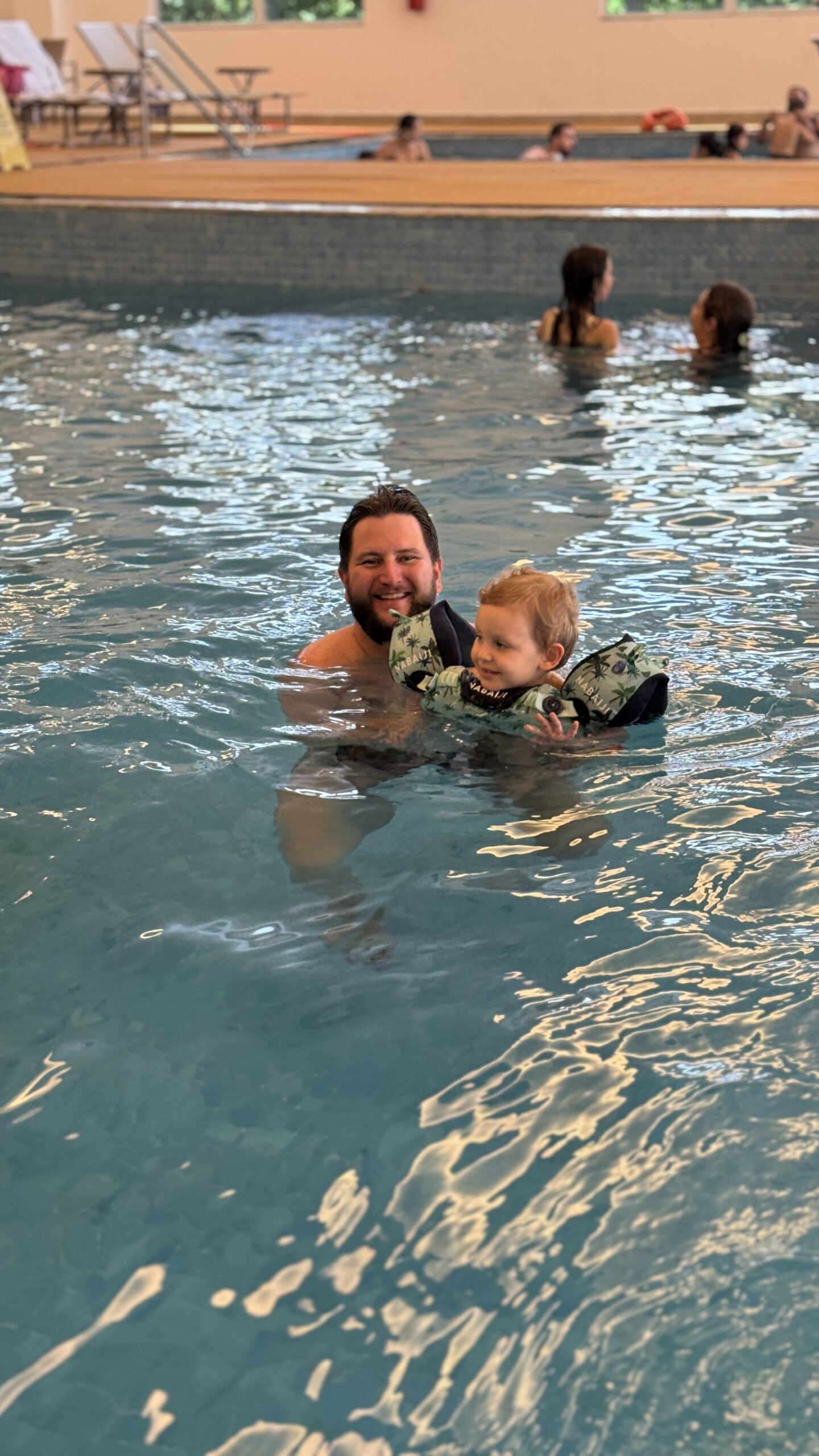 Pai e filho brincando com boia salva-vidas na piscina do parque aquático do Tauá Resort Alexânia