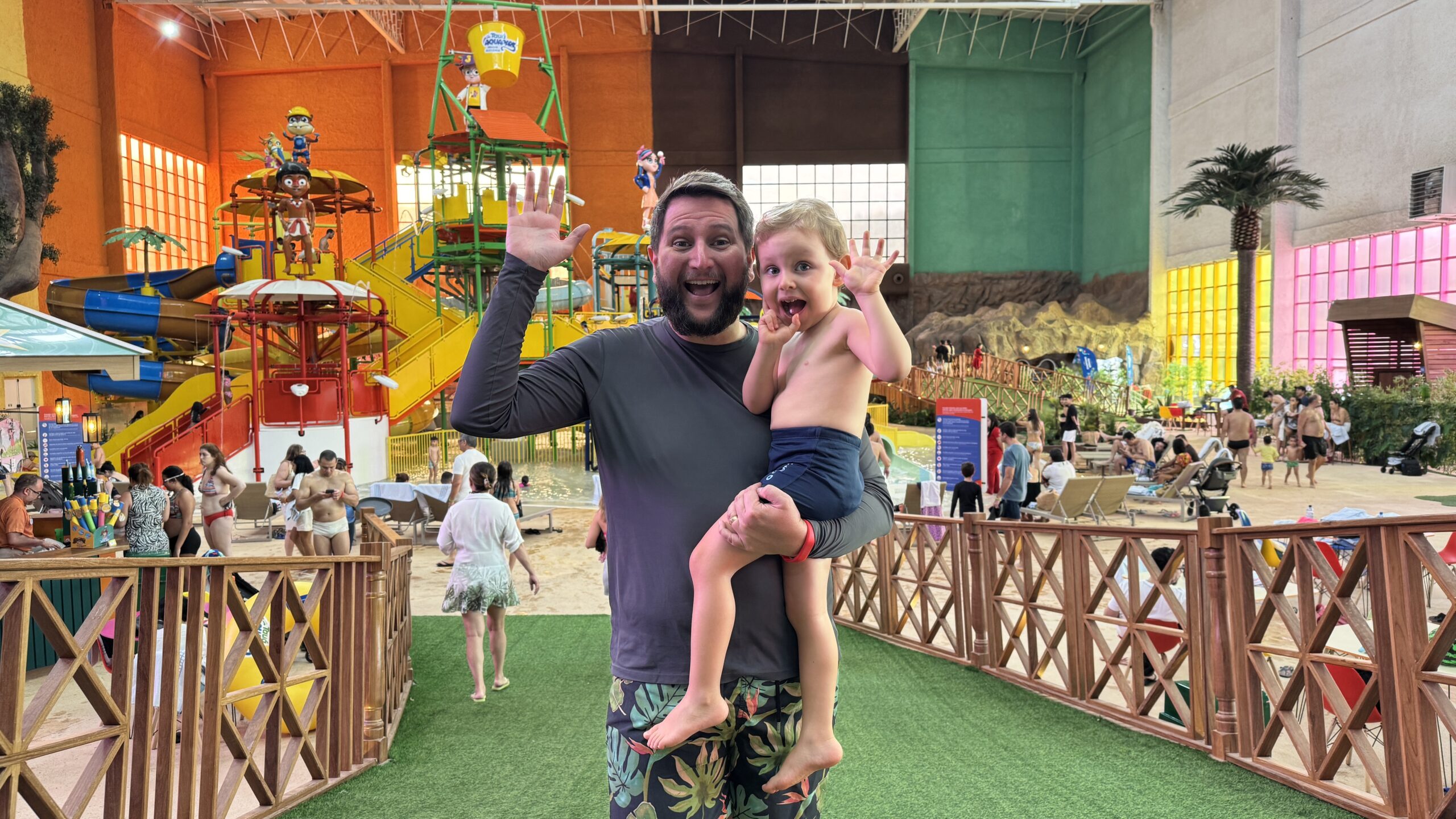 Crianças brincando no parque aquático indoor do Tauá Resort Alexânia com brinquedos coloridos