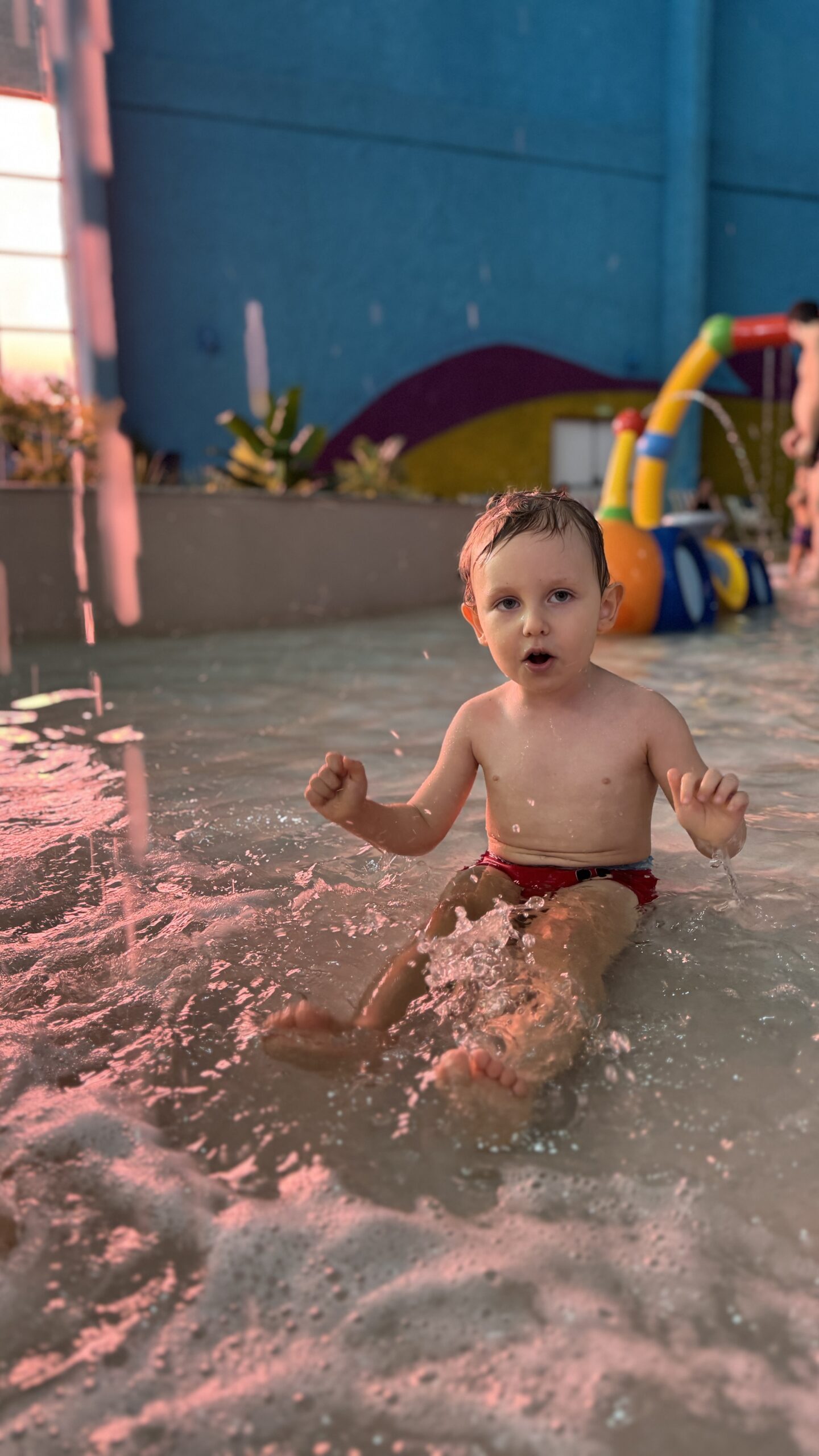 Criança brincando na piscina do Tauá Resort Alexânia durante o pôr do sol