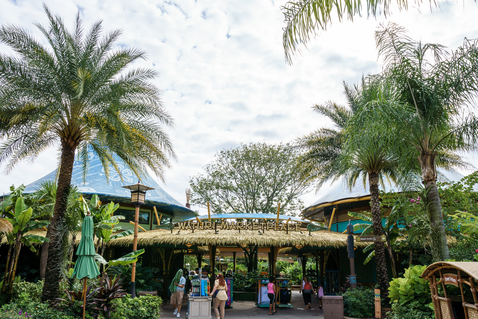 Entrada da Waturi Marketplace no Volcano Bay com sinalizacao de devolucao de toalha