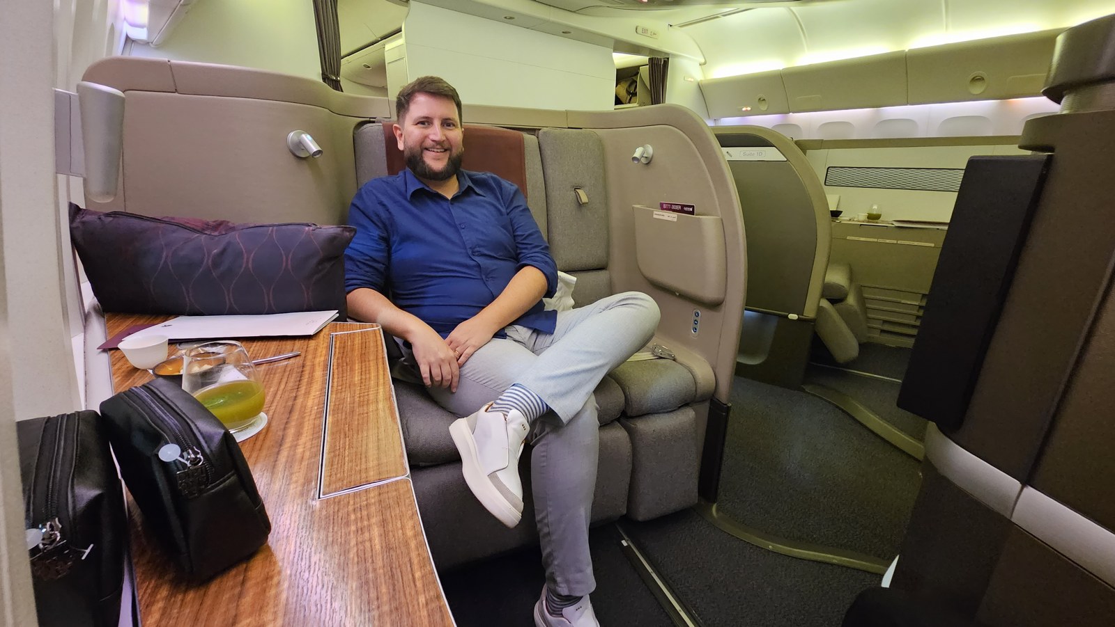 Rudi sentado na suíte da Primeira Classe da Qatar Airways